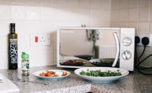 microwave oven with two plates of food in front of it