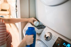 person loading detergent in washer