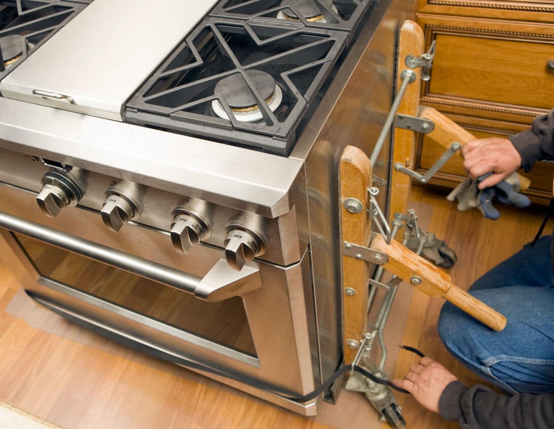 A Landers technician replaces a broken stove with a new one in Baltimore, MD.