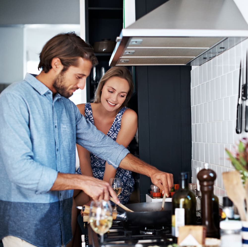 A couple enjoys cooking together after Howard County cooktop repair from Landers.