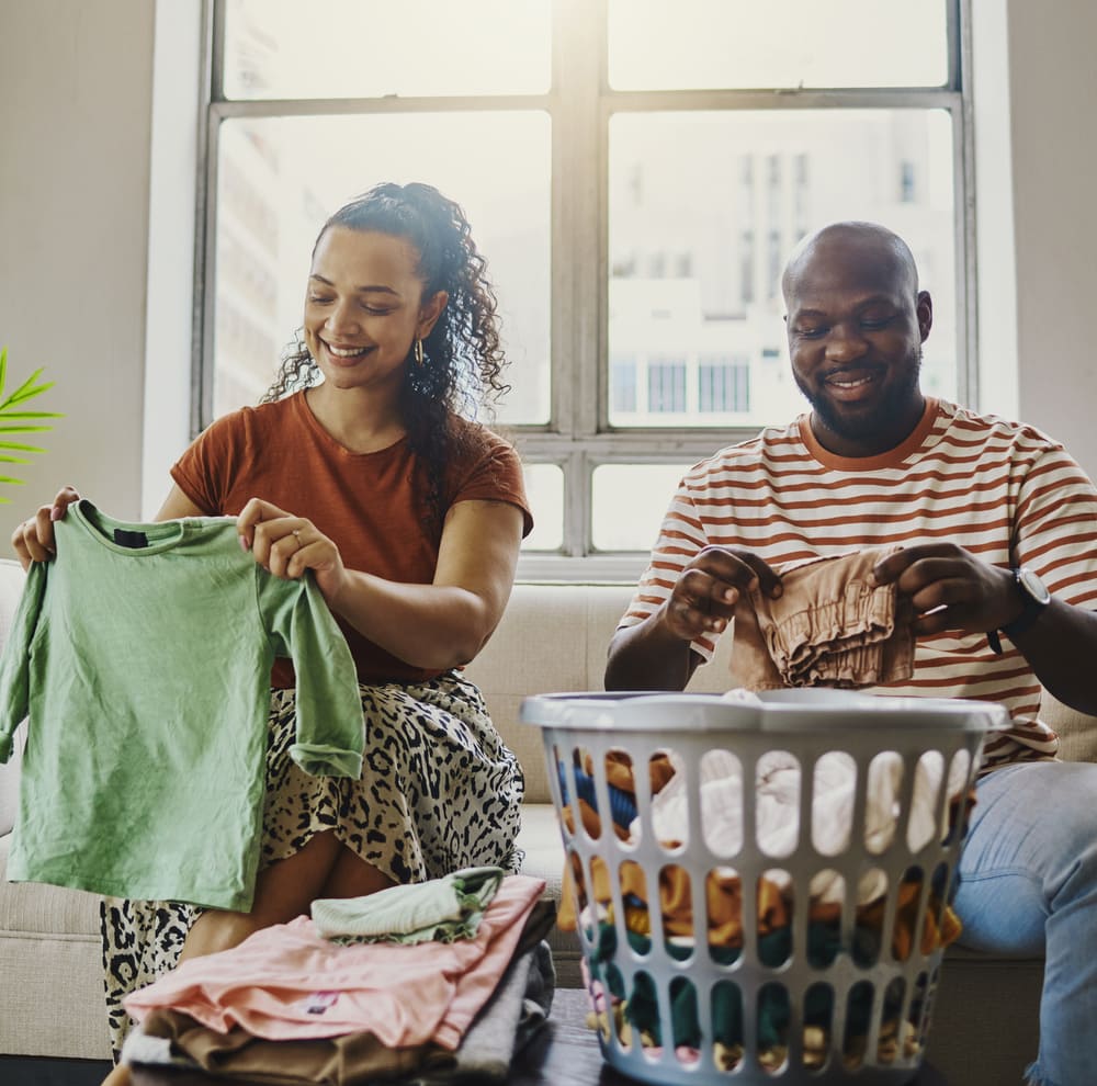 A couple folds their laundry after Howard County dryer repair service from Landers Appliance.