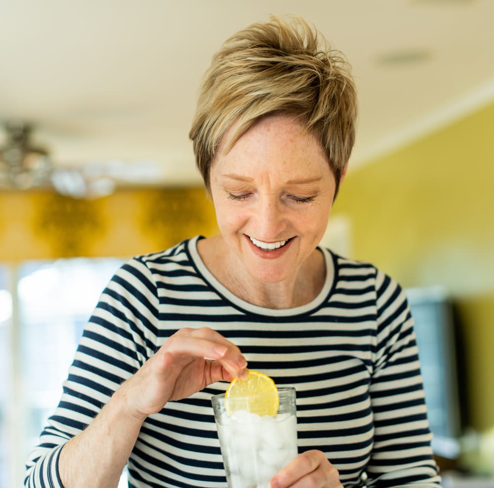 A woman enjoys ice-cold lemonade after ice maker repair in Howard County from Landers Appliance.