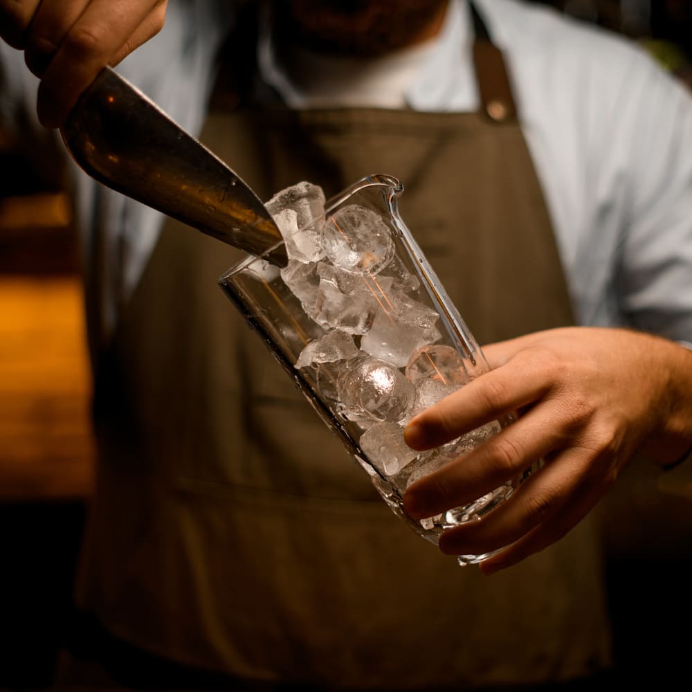 A waiter fills a glass with ice after Rockville ice maker repair from Landers.